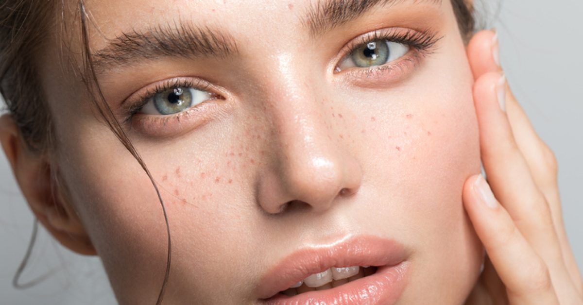 Close up studio shot of a beautiful woman with perfect skin, she touching her face